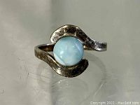 Sterling silver ring showing the round light blue Larimar stone from the front.