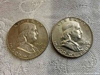 Obverse side of two 1962 Franklin silver half dollar coins, showing the profile of Benjamin Franklin and inscriptions.