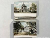 Two stacks of vintage postcards with city and landmark themes from various U.S. locations such as Detroit and Washington D.C.