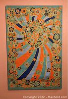 Full view of the rectangular linen tea towel with colorful pop art floral design and swirled ribbons in orange, blue, and green hues showing overall condition and mounted presentation.