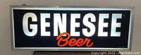 Front view of illuminated Genesee Beer sign showing large white GENESSEE text and red Beer text on black background
