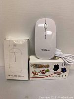 Two white wireless mice, one with charging cable and the other shown with USB receiver and retail box, brand TSMINE