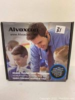 Front side of original product packaging showing Alvoxvom branding, product name 'Wireless Headset/Lapel Microphone', and promotional photo of man speaking with headset.