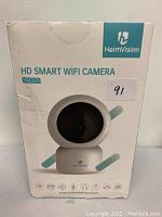 Front view of the boxed HeimVision HD Smart Wifi Camera HM203 in its retail packaging showing the product image and branding.