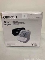 Front of box showing OMRON brand, model BP5250, Silver edition upper arm blood pressure monitor with cuff image