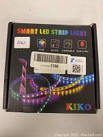 Box showing colorful branding and features including RGB, music sync, dimmable, and built-in mic, marked with a price sticker 100.