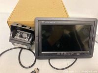 Two different sets of TFT color rear view monitors and backup cameras shown with cables and a box in the background.