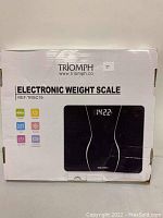 Box of Triomph electronic weight scale showing brand, model REF: TRSC19, and key features including capacity 400 lbs, LCD display, auto off, and step-on technology.