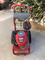 Front view of red Craftsman pressure washer with large black tires and metal base, showing engine cover with 6.75 HP label.