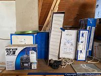 Overall view of multiple drone boxes including Devo 7E remote controller and miscellaneous drone parts.