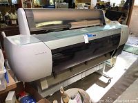 Front angle view of Epson Ultrachrome large-format industrial printer showing printer body and transparent cover.