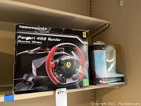 Thrustmaster Ferrari 458 Spider Racing Wheel box and Cybertronics joystick box on shelf