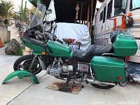 Side profile showing green fairing, windshield, seat, side saddlebags and top case