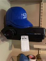 Kodak Carousel 5400 projector front and side view with blue Dodgers helmet atop it, showing model label and helmet logo.