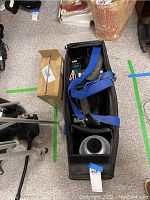 Top-down view of photography light stand tripod and carrying bag with shoulder strap on floor