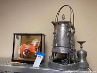 Overview of lot including silver plated tea server, pewter cups, and horse figurine in display case