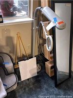 Work lamp with magnifying glass and wooden floor easel in corner near window