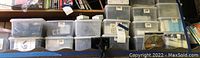 Large collection of translucent plastic bins filled with various electronic components and devices, labeled and stacked.