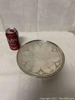 Full view of round platter on white backdrop with soda can for scale
