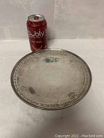 Overall top view of round silver platter next to a Bubly can for scale.