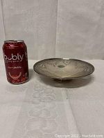 Front view of round shallow dish next to soda can for scale