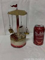 Full view of carousel next to soda can for scale