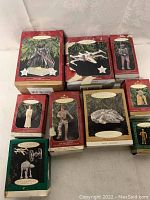 Photo showing nine original Hallmark Star Wars ornaments boxes in differing condition, arranged on a white cloth background.