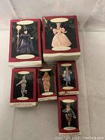 Photo showing all six unopened boxed ornaments from Hallmark Wizard of Oz collection. Boxes show varying condition.
