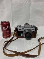 Front view of Kiev camera mounted in brown leather case, lens visible