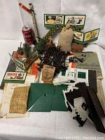 Overview of all included vintage Lionel accessories, model buildings, trees, billboards, bridge, and paperwork