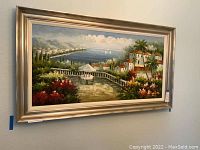 Full view of the framed acrylic painting depicting a Mediterranean coastal scene with white buildings, sea, sailboats, and vibrant flora.