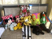 Full view of group showing all dolls on brown fabric patio chair
