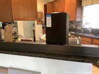 Photo shows LG Wi-Fi sound bar and subwoofer speaker on kitchen counter, subwoofer box is in background and sound bar is in foreground.