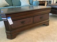 Full front view of coffee table with closed top showing two drawers and hardware