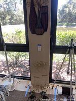 Gold tone plate holders with branch-like design and flower shapes placed on floor