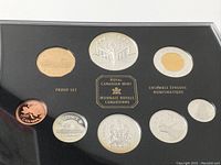 Overview of 9 proof coins arranged in black display case showing various denominations and Canadian imagery