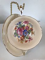 Top view showing floral design inside the tea cup against pale peach background and saucer below.