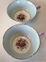 Two Paragon teacups viewed from above showing interior floral decoration and gold rim
