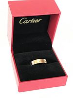 Cartier Love ring displayed inside red Cartier jewelry box with black interior, showing the ring from front.