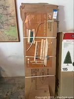 Boxed Windsor Design 60 inch wooden workbench standing upright, showing front printed label with product image and description.