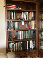 Full bookshelf from a distance showing all five shelves with books and decor items.