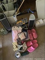 Wide view of lot showing heater, fan, grabbers, Crocs and various candles and decor