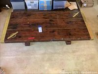 Full top view of the rectangular wooden table on carpet with visible rope and brass fittings on the corners.