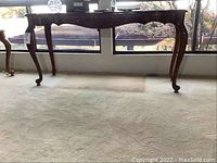 Full view of the wood and glass side table against window background showing overall size and shape