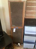 Pair of vintage wooden stereo speakers stacked, showing fabric grille and KLH brand badges on front bottom left.