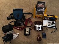 Overview of collection showing all cameras and cases on beige carpet