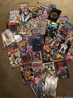Overview of assorted comic books from Image Comics scattered on carpet, showing various superhero and fantasy themed cover arts, with visible wear and creases.