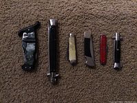 Group view of all six pocket knives showing different styles and conditions.