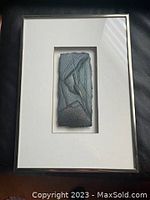 Full view of the framed textured abstract art piece showing the entire frame and mat board surrounding the artwork.