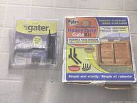 Photo showing Sure-Lock gate latch in sealed plastic packaging and Pylex Heavy Duty Gate Kit box side by side on a wall.